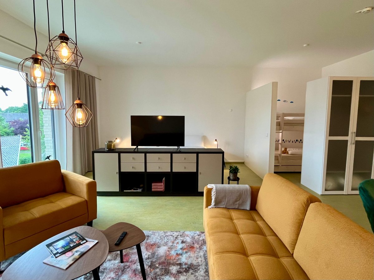 Wohnzimmer mit gelben Sofas und TV Board 