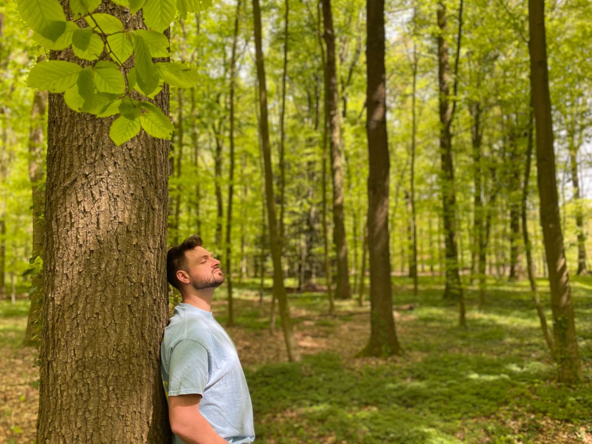 Ein Mann steht an einen Baum gelehnt